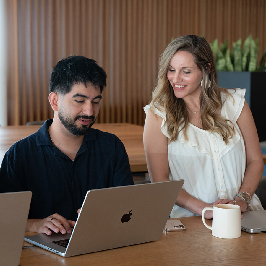 A man and woman working on a laptop together.