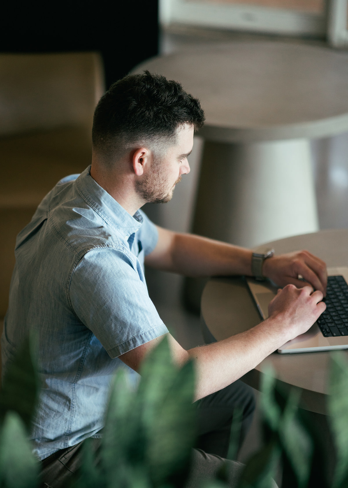 A man typing on a laptop computer.