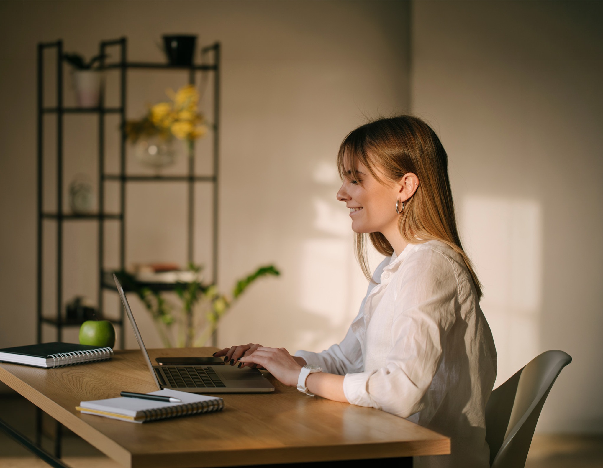 Woman working on a laptop at a desk.
