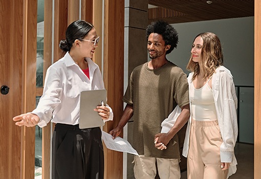 A tour guide showing a man and woman an apartment amenity.